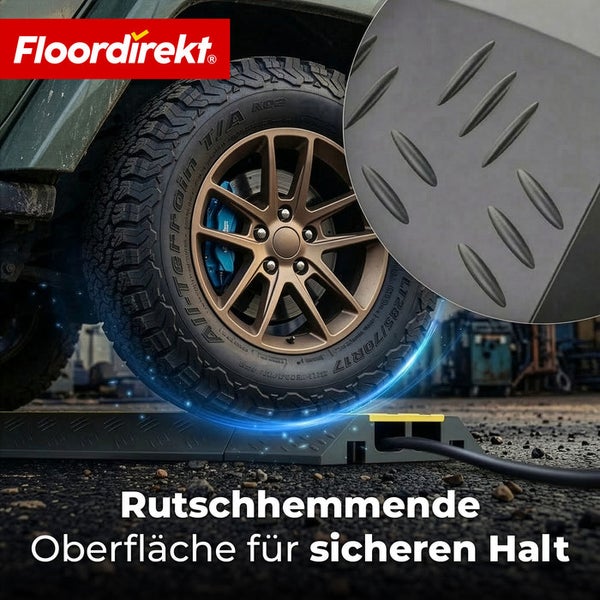 Floordirekt Logo. Ein Geländewagenreifen fährt über eine schwarze Kabelbrücke mit rutschhemmender Riffelblech-Oberfläche.