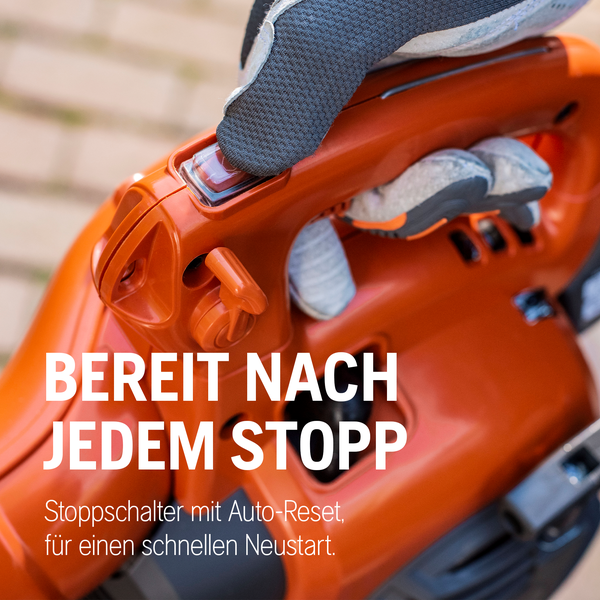 Nahaufnahme eines orangefarbenen Laubbläsers mit einer Hand, die den Startknopf betätigt