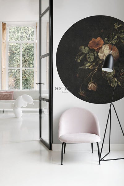 Helles Zimmer mit rosa Stuhl, Stehlampe und runder Wanddekoration mit Blumenmotiv