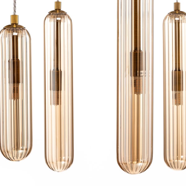 Detail einer Hängeleuchte mit zylindrischen, geriffelten Glasschirmen in Bernstein und Fassungen aus Messing.