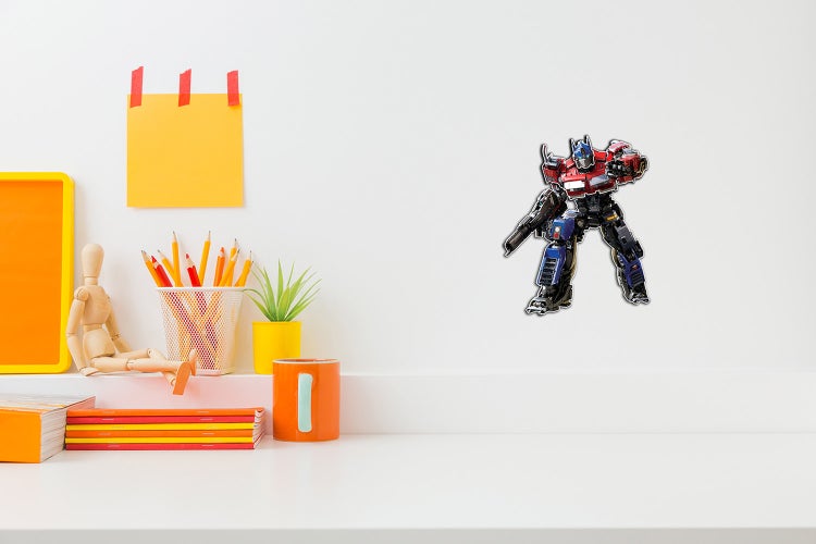 Selbstklebendes Wandtattoo Transformers Optimus Prime in einem hellen, organisierten Kinderzimmer über einem Schreibtisch.