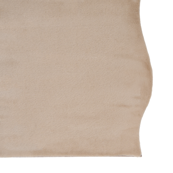 Beiger weicher Kunstfellteppich mit kurzem Flor und unregelmäßigem Rand aus synthetischem Material.