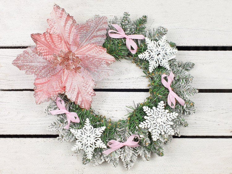 Weihnachtskranz dekoriert mit einer großen Blüte, Schneeflocken und kleinen Schleifen auf Tannenoptik.