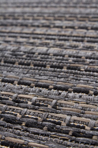 Nahaufnahme eines gewebten Teppichs in Grau, Schwarz und Beige mit flachgewebter Struktur.