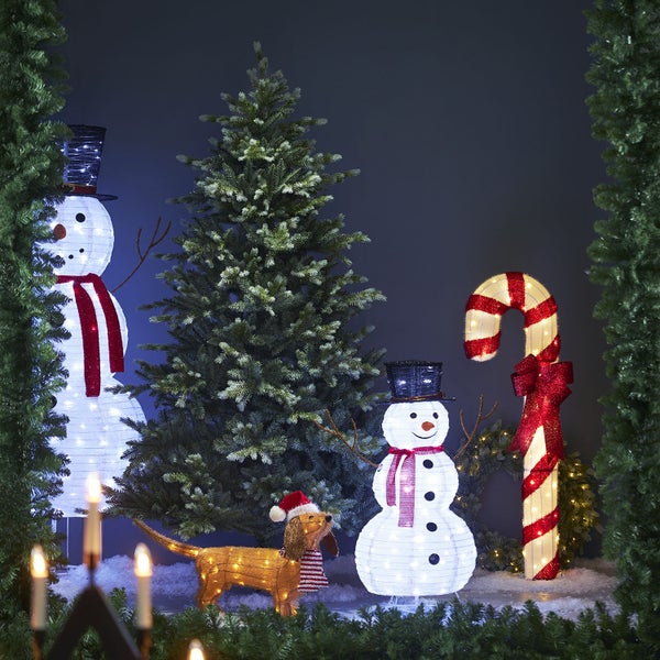 Festliche Szene mit beleuchteten Schneemännern, Zuckerstange und Dackel als Weihnachtsdekoration