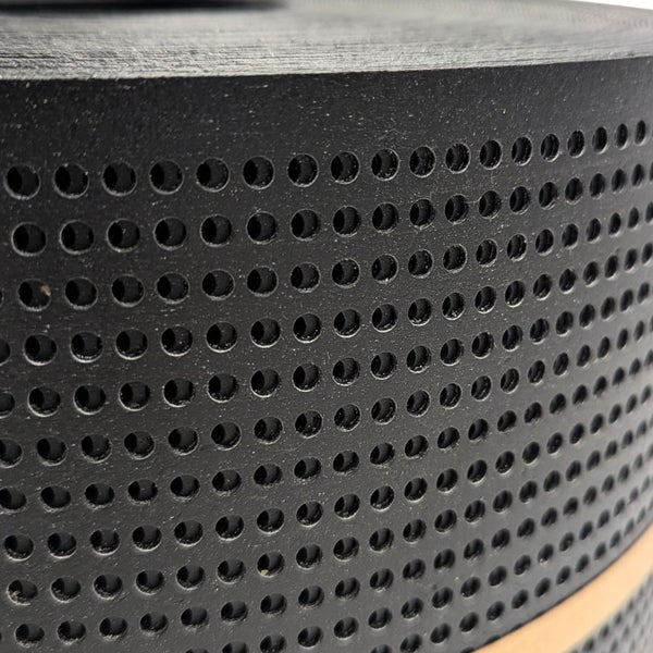 Detailaufnahme eines perforierten, zylinderförmigen Objekts