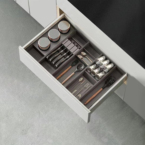 Organisierte Küchenschublade mit Besteckkasteneinsätzen für Messer, Gewürze und Küchenutensilien.
