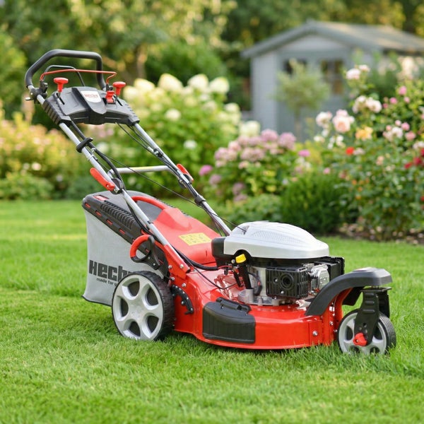 Roter Rasenmäher mit Fangkorb auf Rasen