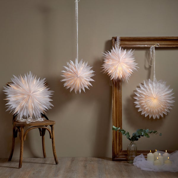 Gartenzwerg mit Säge auf Baumstamm mit LED-Leuchte