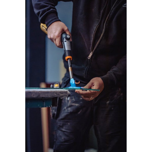 Handwerker erhitzt Glas mit einem Gasbrenner