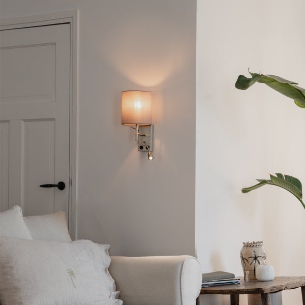 Wohnraum mit Wandleuchte mit Lesearm, Sofa und Tisch mit Dekoration