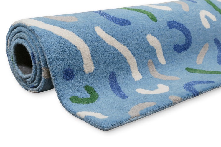 Aufgerollter blauer Teppich mit abstraktem Muster aus geschwungenen Linien und Punkten.