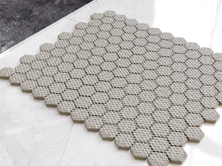 Sechseckige Mosaikfliesen auf einem Trägernetz für Wand und Boden.