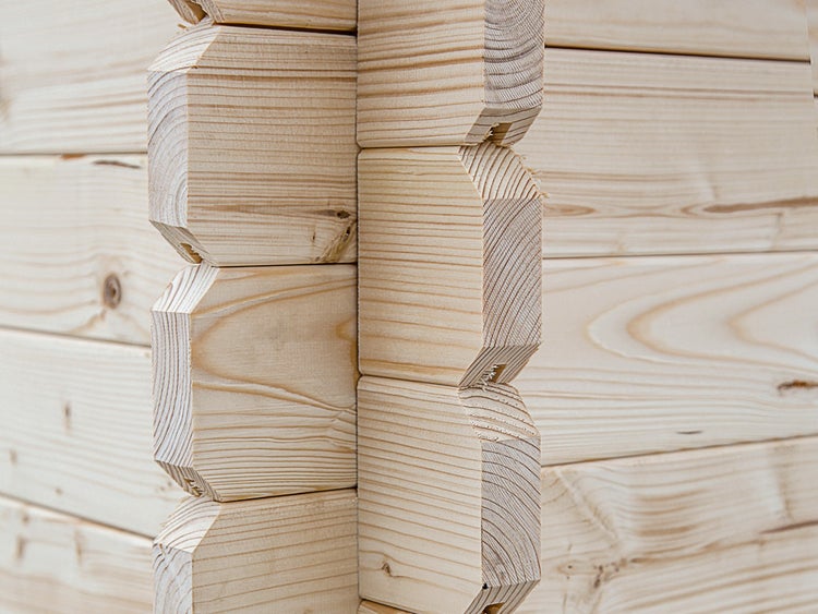 Detailansicht einer Eckverbindung von Blockbohlen aus Holz für ein Gartenhaus.