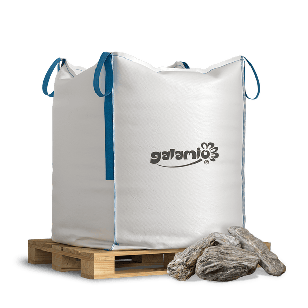Galamio Ziersteine im weißen Big Bag mit blauen Schlaufen auf einer Holzpalette mit grauen Natursteinen.