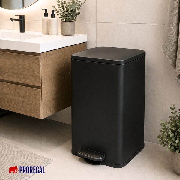Schwarzer Treteimer aus Metall in einem hellen, organisierten Badezimmer neben einem Holzwaschtisch mit weißem Waschbecken. Proregal Logo.