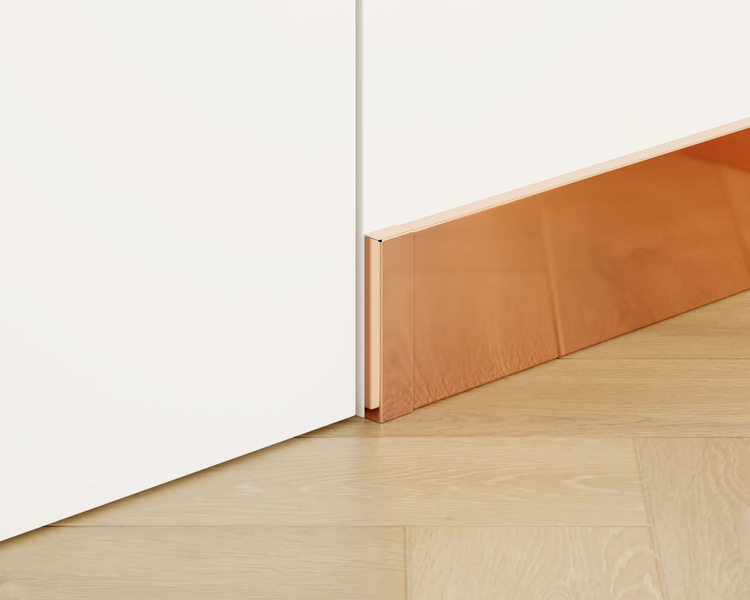Sockelleiste in Kupferoptik an einer weißen Wand