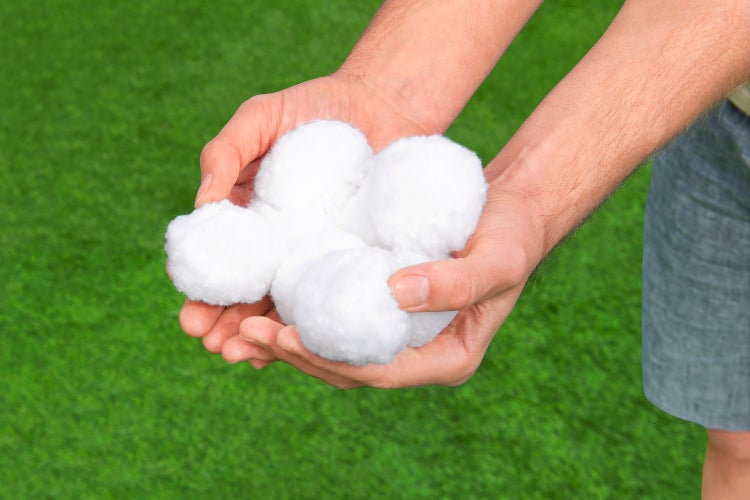 Eine Hand hält mehrere Füllwattebäusche