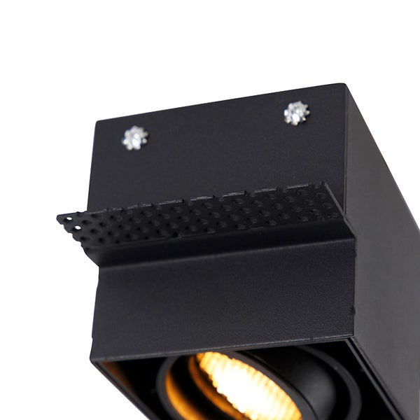 Quadratischer Einbaustrahler aus schwarzem Metall mit perforierter Halterung und sichtbarer Lichtquelle.