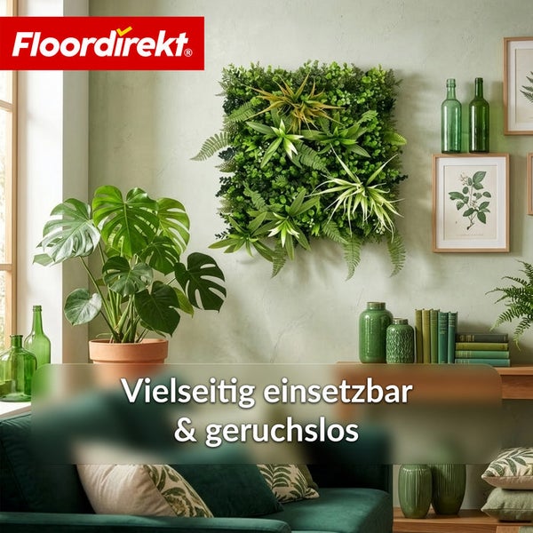Helles Wohnzimmer mit künstlicher Pflanzenwand, einer Monstera im Topf, botanischer Wanddekoration und dem Floordirekt Logo.