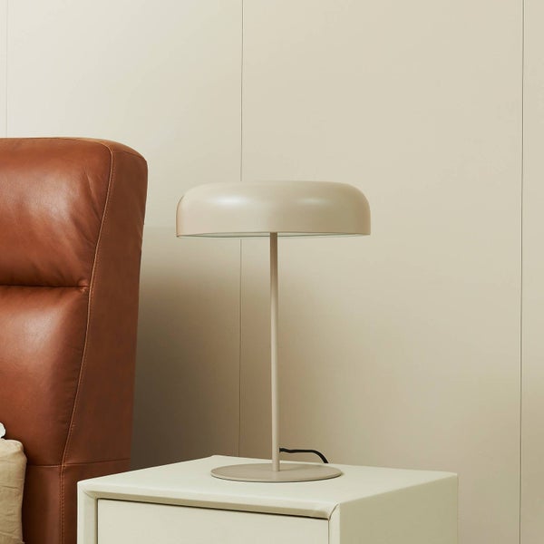 Dekorative Tischleuchte auf einem Nachttisch neben einem Sessel