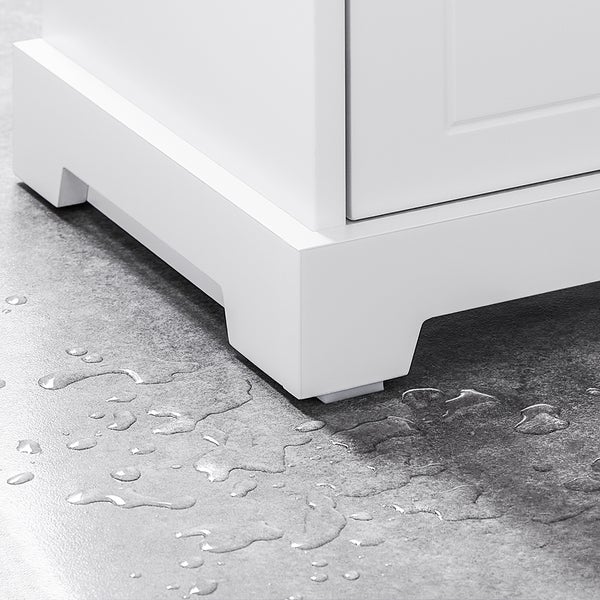 Detailaufnahme eines weißen Badezimmerschranks mit Spritzwasser auf dem Boden