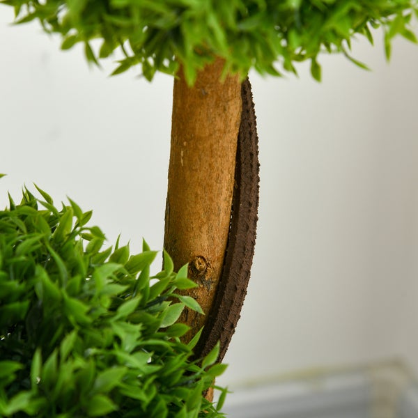 Nahaufnahme eines Stammes und der Blätter einer künstlichen Buchsbaumkugel.