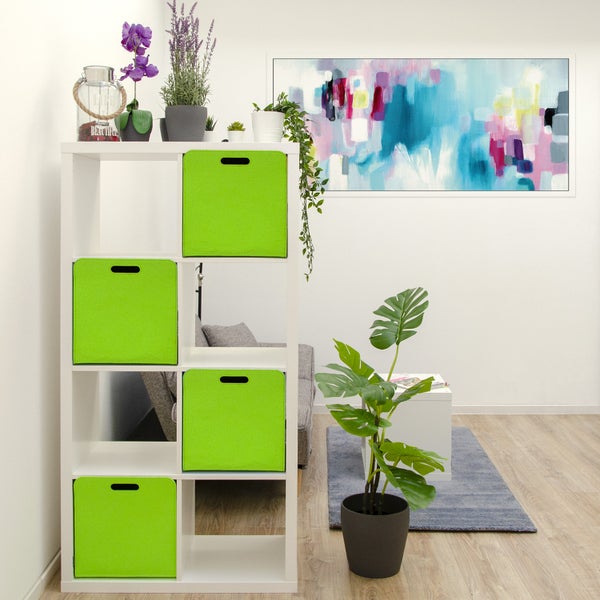 Weißes Regal mit vier grünen Aufbewahrungsboxen in einem modern eingerichteten Wohnzimmer mit Pflanzen und abstraktem Wandbild.
