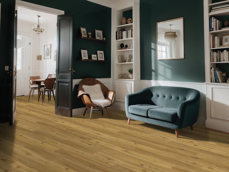 Geräumiges, organisiertes Wohnzimmer mit Bodenbelag in Holzoptik, Wandpaneelen, Sofa, Sessel mit Fellauflage und Regalen.