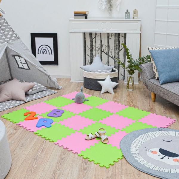 Bunte Puzzlematte im Kinderzimmer auf Holzboden neben Spielzelt und Sofa. Helle, organisierte Spielumgebung aus weichem Schaumstoff.