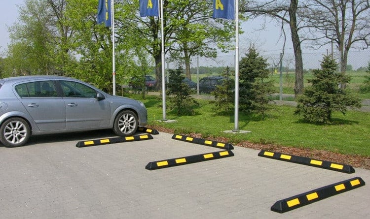 Szene mit Auto und mehreren Parkplatzbegrenzern auf einem Parkplatz.