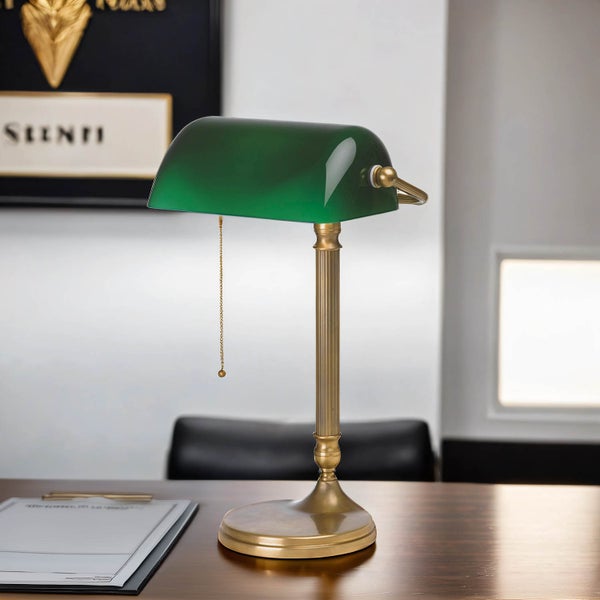 Grüne Schreibtischlampe mit Goldfuß auf einem Schreibtisch