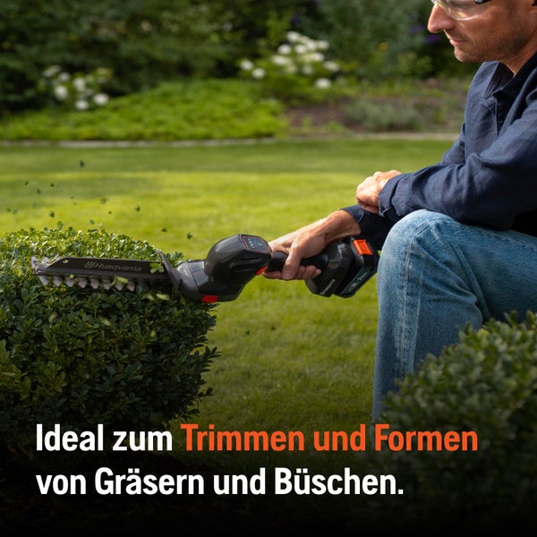 Akku-Grasschere beim Trimmen eines Busches im Garten