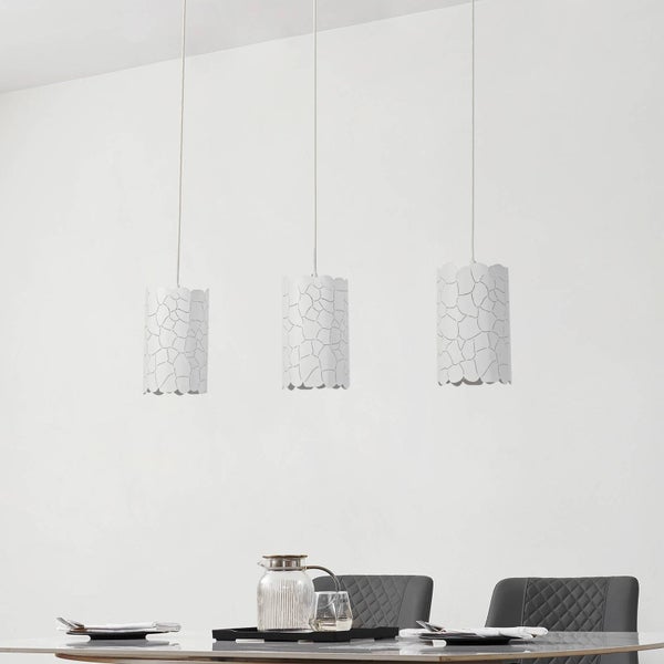 Drei Pendelleuchten mit einem abstrakten Muster über einem Esstisch