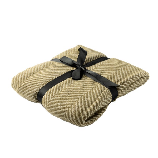 Zusammengefaltete Wolldecke mit Fischgrätmuster und Schleife