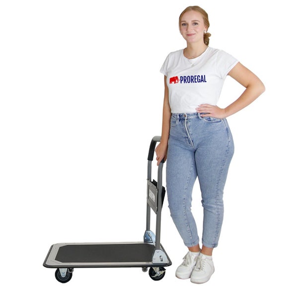 Eine Frau steht neben einem Transportwagen mit Rollen für den Transport von Waren.
