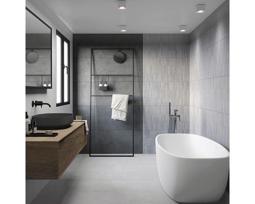 Modernes Badezimmer mit freistehender Badewanne, Waschtisch mit schwarzem Aufsatzwaschbecken und grauen Fliesen