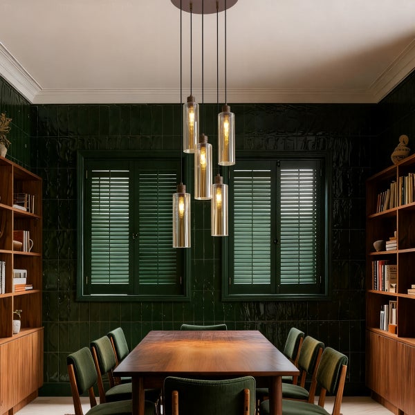 Esszimmer mit Esstisch, Stühlen, Bücherregalen und einer Pendelleuchte mit mehreren Lampen