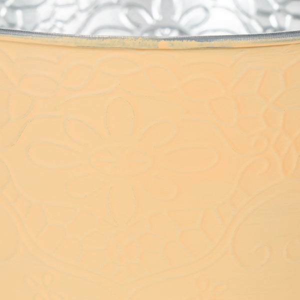 Nahaufnahme eines Metall-Übertopfs mit eingeprägtem Blumenmuster.