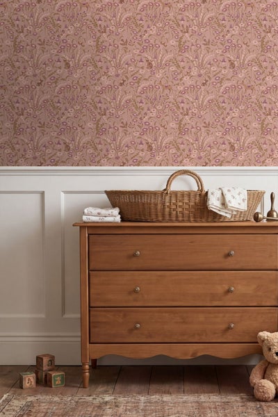 Kinderzimmer mit Vliestapete mit Blumen- und Waldtiermotiven über einer Wandtäfelung und einem Kinderbett aus Holz.