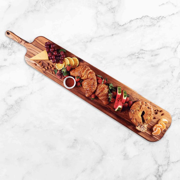Holzbrett mit Käse, Weintrauben, Croissants und anderen Speisen