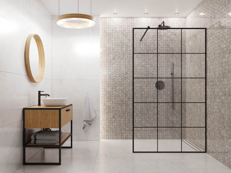 Modernes helles Badezimmer mit Walk-In Dusche, schwarzer Glastrennwand, Waschtisch aus Holz, rundem Spiegel und Mosaikfliesen im Fischgrätmuster.