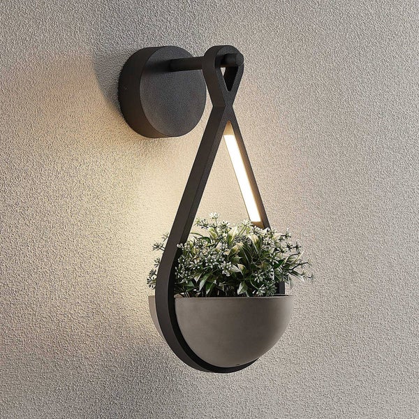 Moderne schwarze Wandleuchte mit integriertem Pflanzgefäß in Betonoptik, tropfenförmigem Rahmen und LED-Licht.