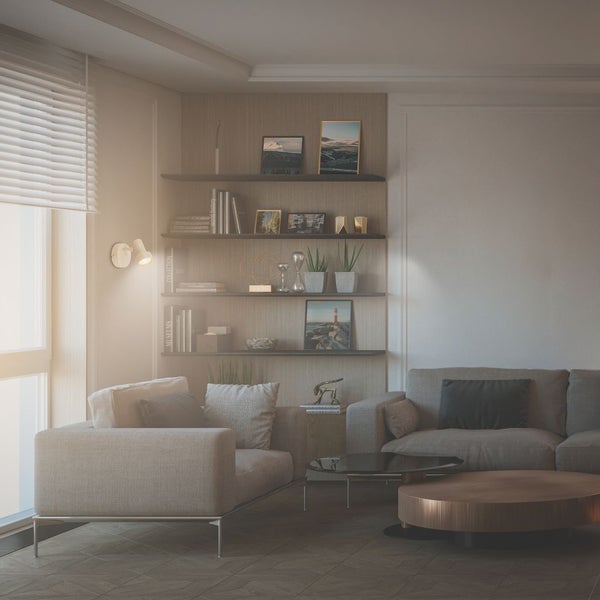 Helles Wohnzimmer mit modernem Sofa, Sessel und Couchtisch aus Holz sowie Wandregalen mit Büchern und Dekoration.