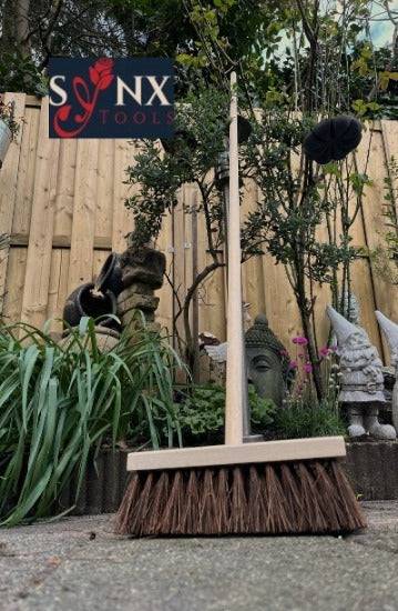 Bürste mit Holzgriff und Borsten im Außenbereich