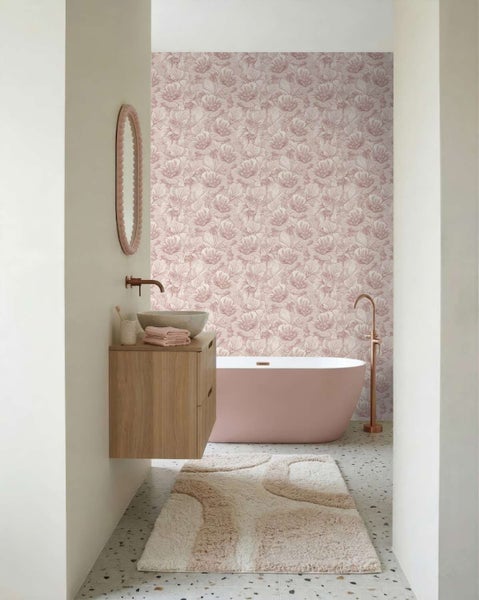 Modernes Badezimmer mit blumiger Tapete, freistehender Badewanne, Holzwaschbeckenunterschrank und gemustertem Bodenfliesenbelag.