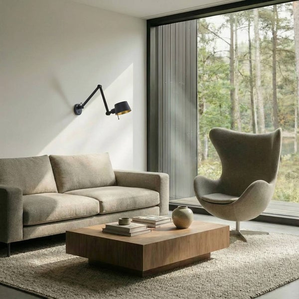 Wohnzimmer mit Sofa, Sessel, Couchtisch und Wandleuchte