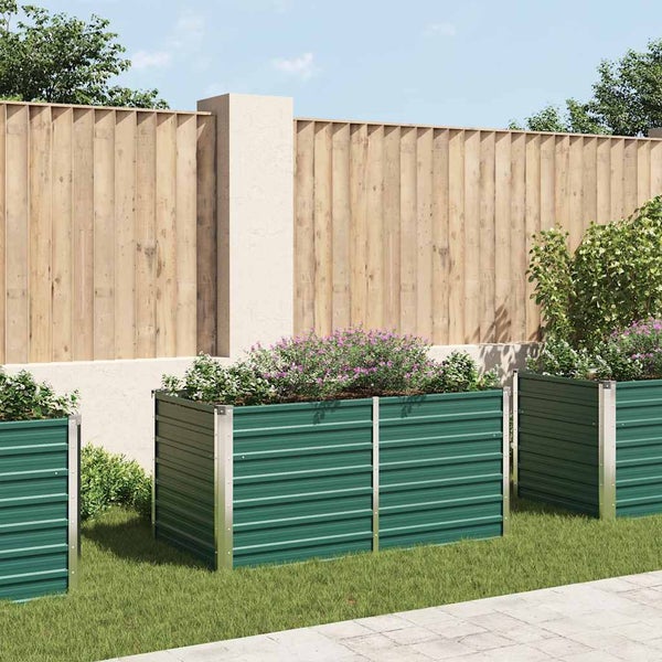 Garten Szene mit erhöhten, grünen Pflanzkästen und Holz Zaun im Hintergrund.