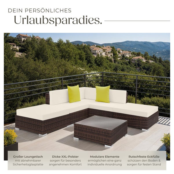 Große Loungegruppe mit Tisch und dicken Polstern auf einer Terrasse mit Blick auf eine Landschaft.