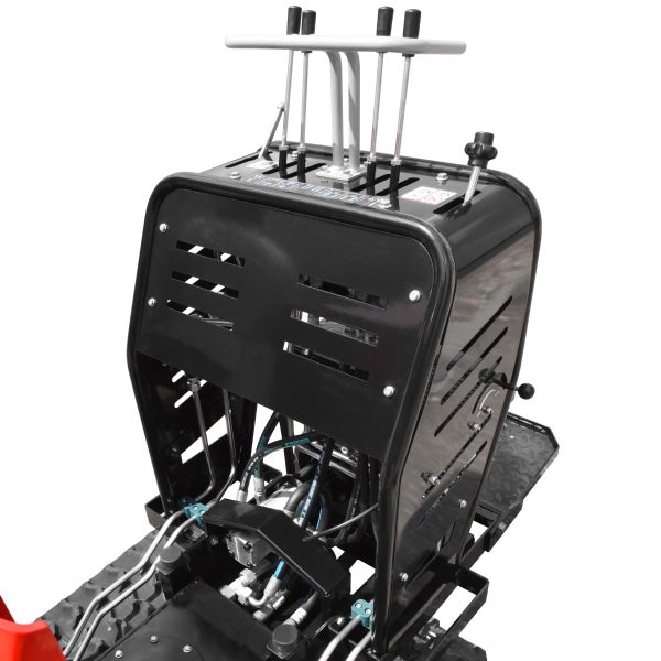 Bedienkonsole einer Baumaschine mit Hebeln, schwarzem Metallgehäuse mit Lüftungsschlitzen und Hydraulikleitungen.